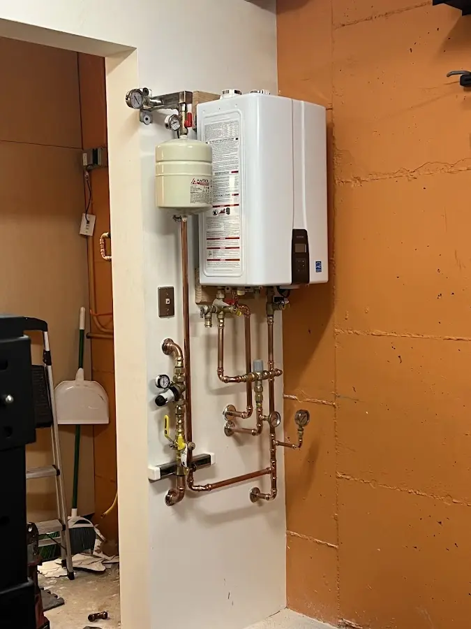 Plumbing technician inspecting water heater connections in Highland Heights